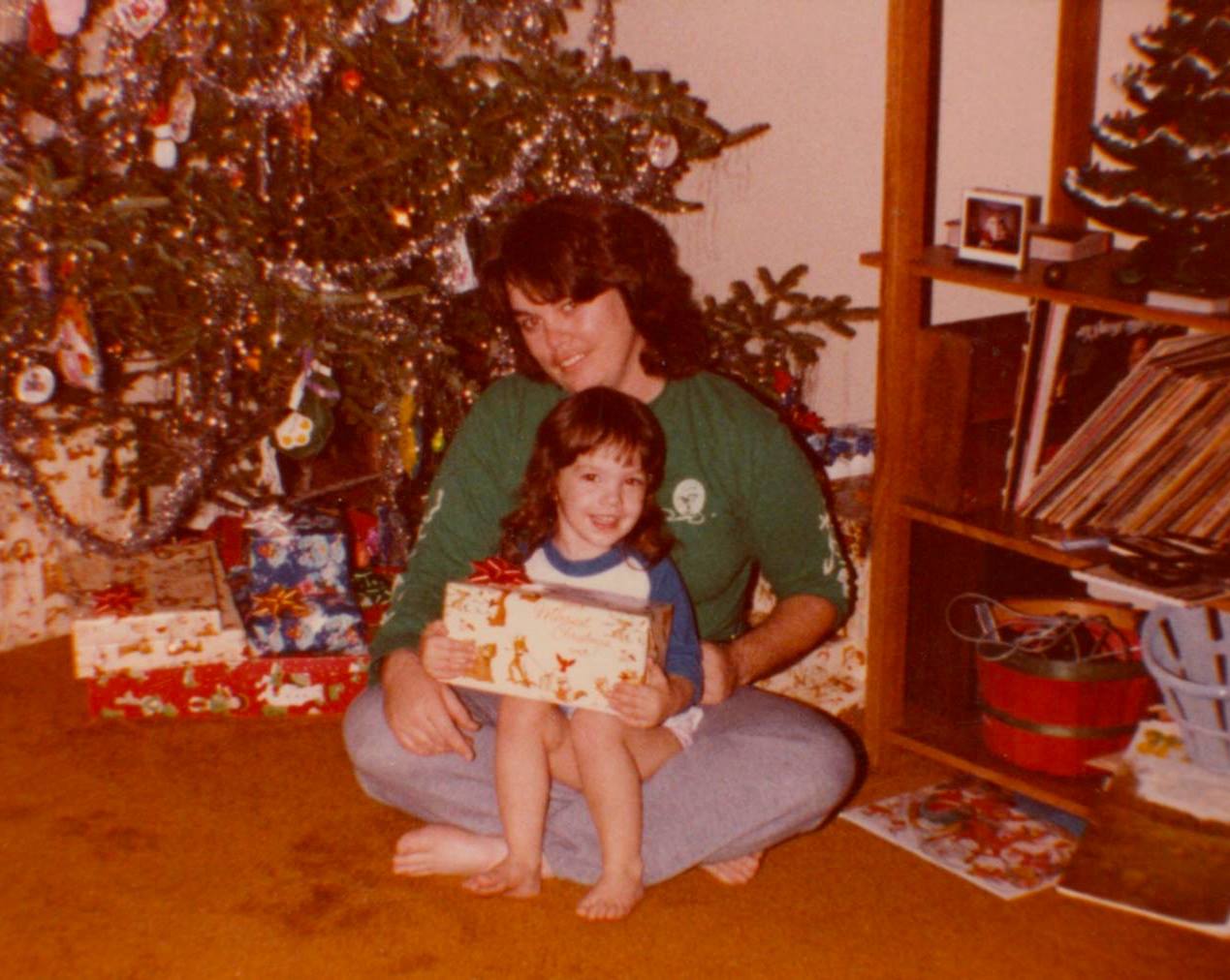 Michelle as a child with her mom by a Christmas tree